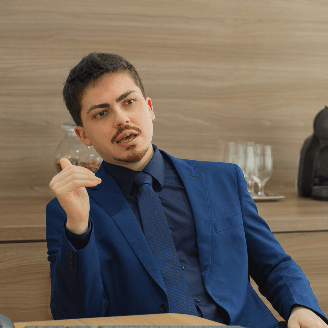 O advogado Carlos Alegre, vestido com terno azul-royal, gesticulando durante a fala.